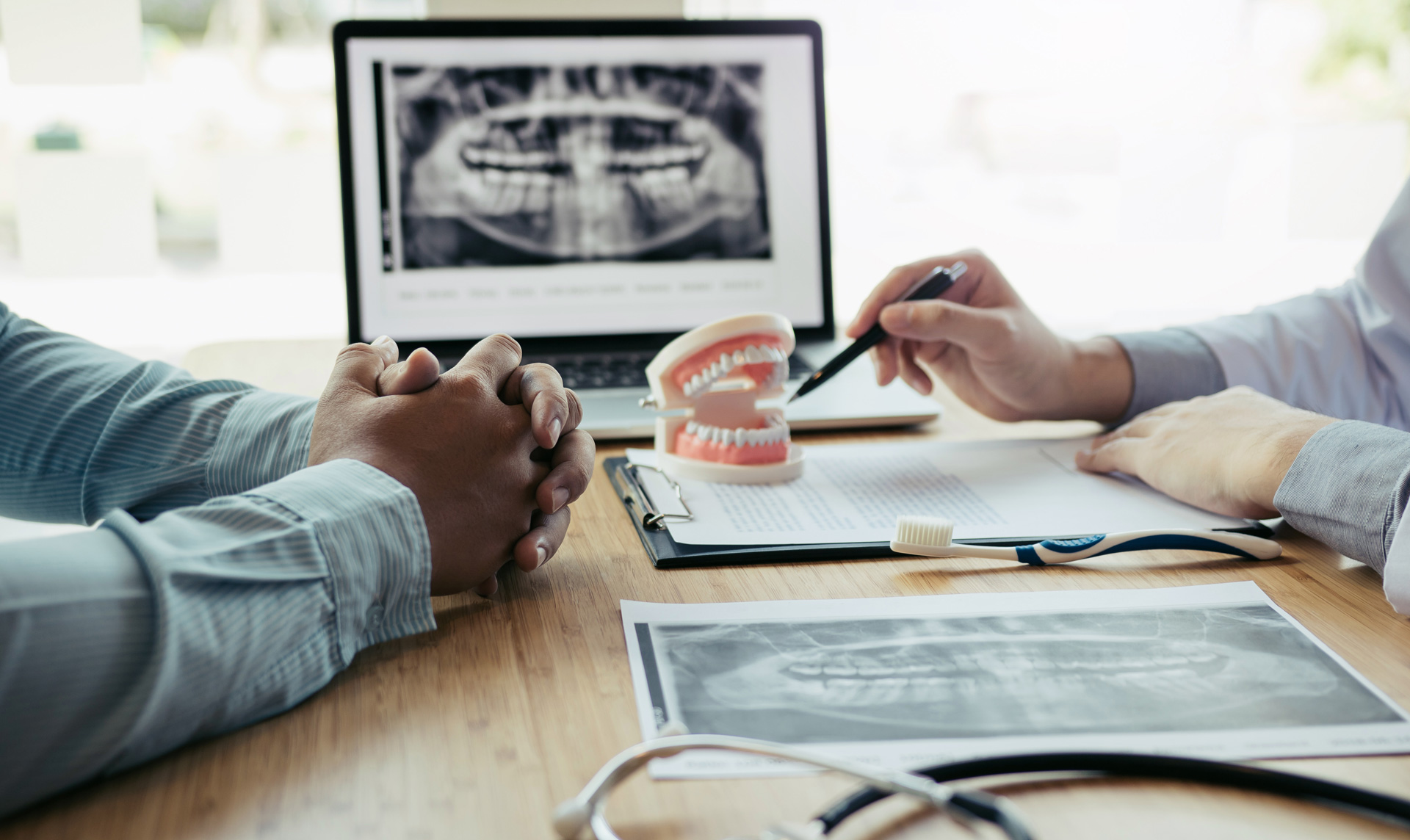 A dentist conducting an oral cancer screening and reviewing an x-ray.