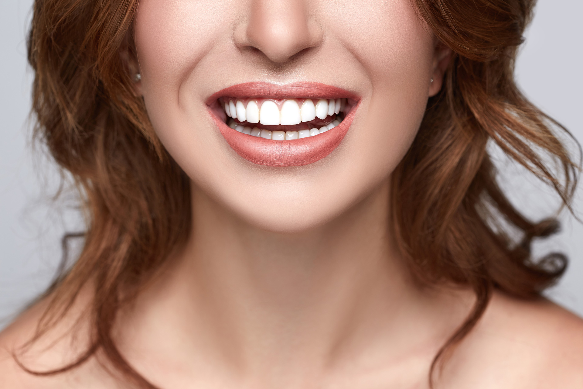 A woman with bright white teeth smiling warmly.